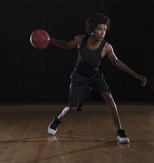 African American man playing basketball on court