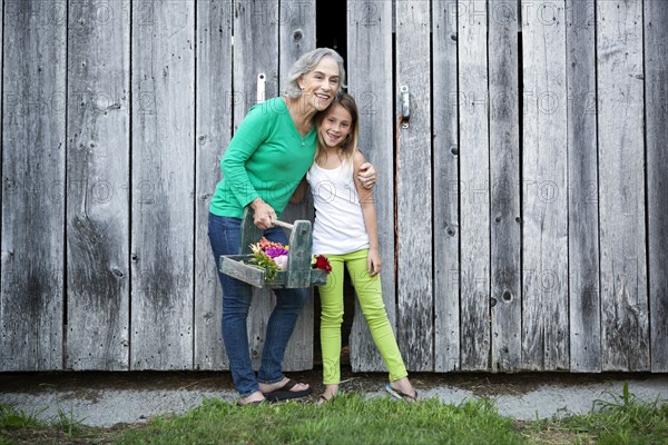 Caucasian grandmother and granddaughter smiling on farm