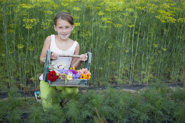 Caucasian girl holding basket of flowers