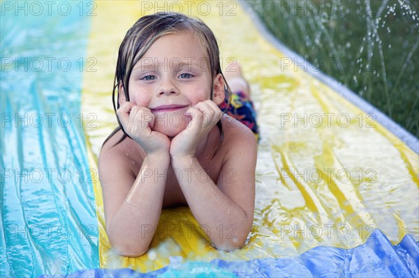 Caucasian boy smiling on water slide