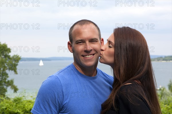 Caucasian woman kissing man outdoors