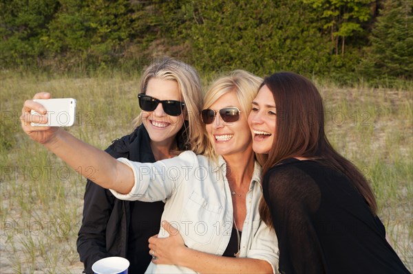 Caucasian women taking cell phone photograph outdoors