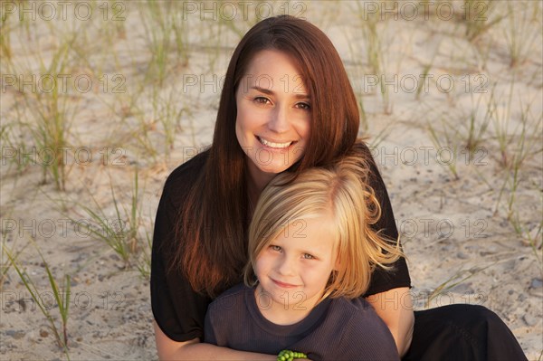 Caucasian mother hugging son on beach