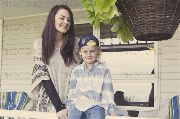 Caucasian mother and son smiling on porch