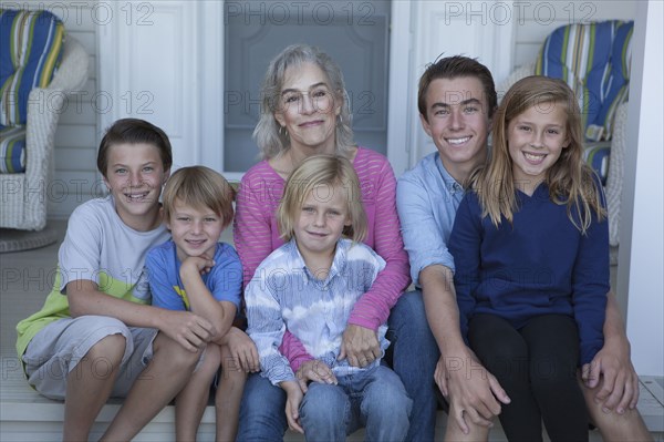 Caucasian grandmother and grandchildren smiling on porch