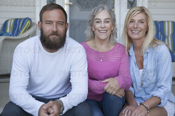 Caucasian mother and children smiling on porch