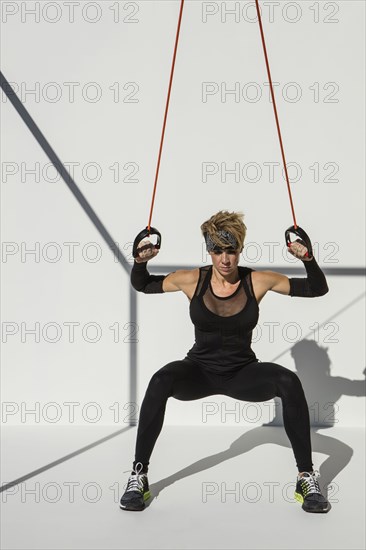 Caucasian athlete exercising with resistance cables