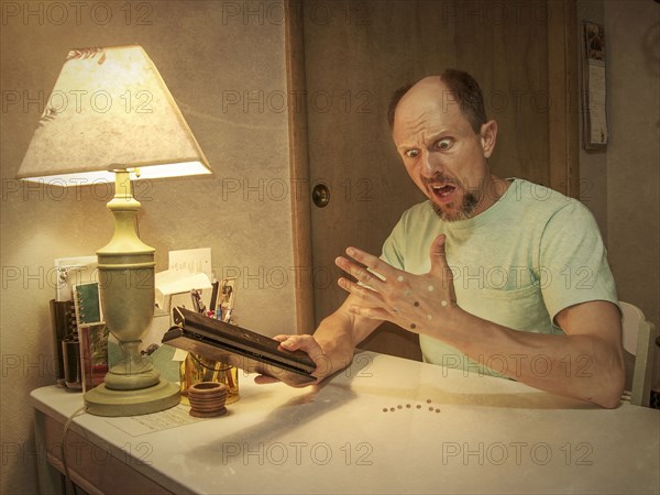 Caucasian man with holes punched in hand