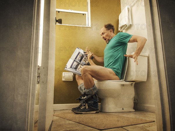 Hand reaching up for Caucasian man on toilet