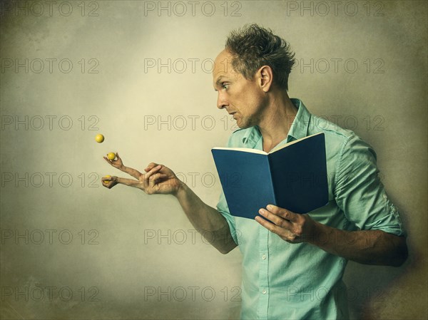 Caucasian man juggling fruit with finger hands