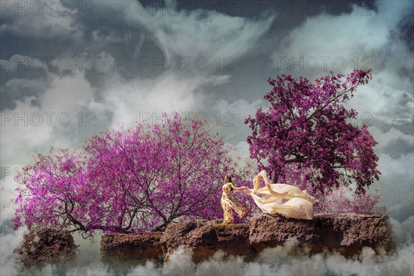 Chinese woman holding fabric in fog on windy rock