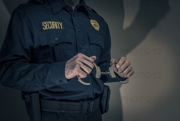 Caucasian security officer holding handcuffs