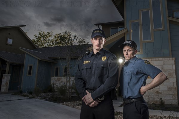 Caucasian security officers posing with flashlight