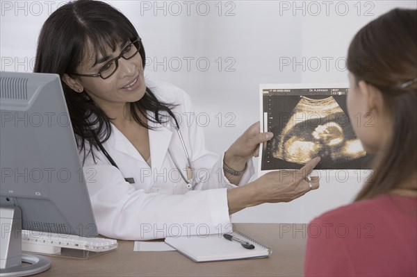 Female doctor showing sonogram to patient