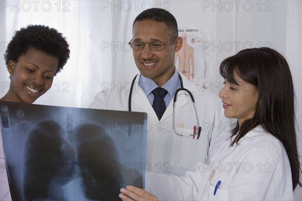Multi-ethnic doctors and patient looking at x-ray