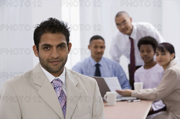 Indian businessman with co-workers in background