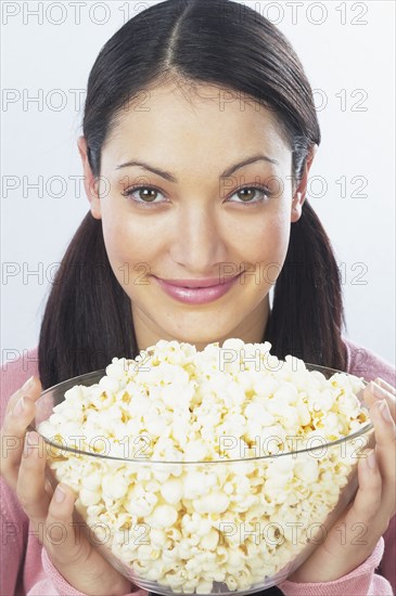 Young woman holding bowl of popcorn