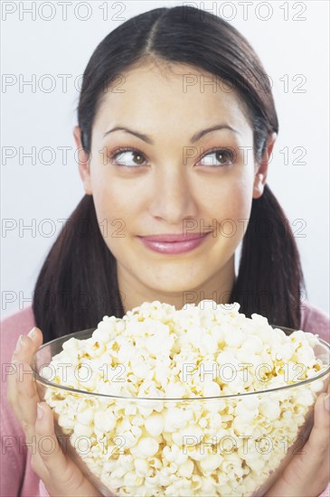 Young woman holding bowl of popcorn