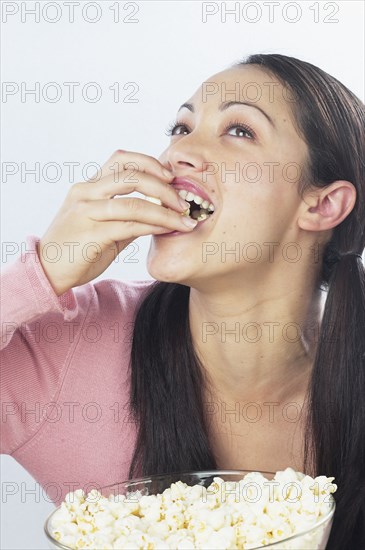 Young woman eating popcorn