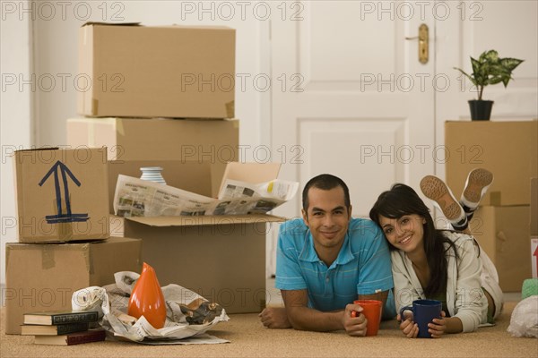 Young couple next to unpacked moving boxes