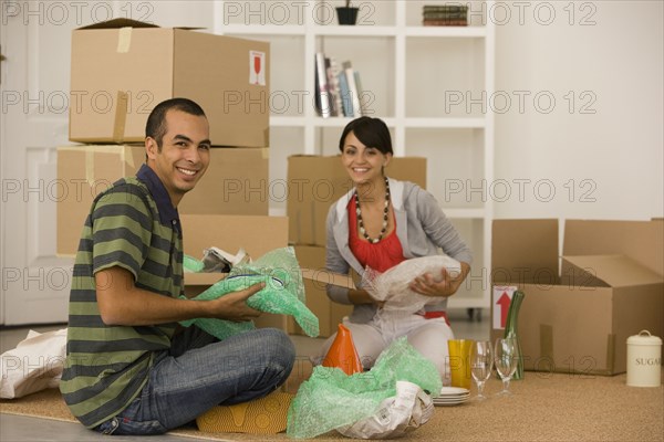 Young couple packing moving boxes