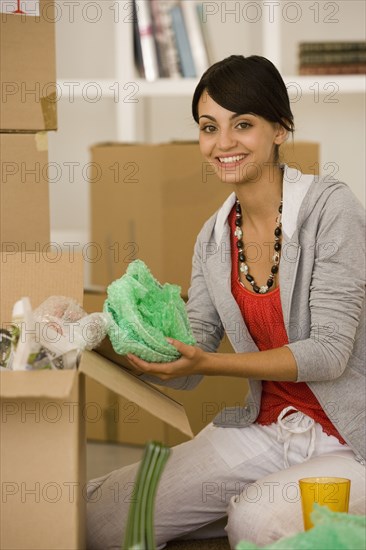 Young woman packing moving boxes