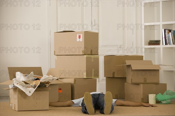 Man laying on floor next to moving boxes