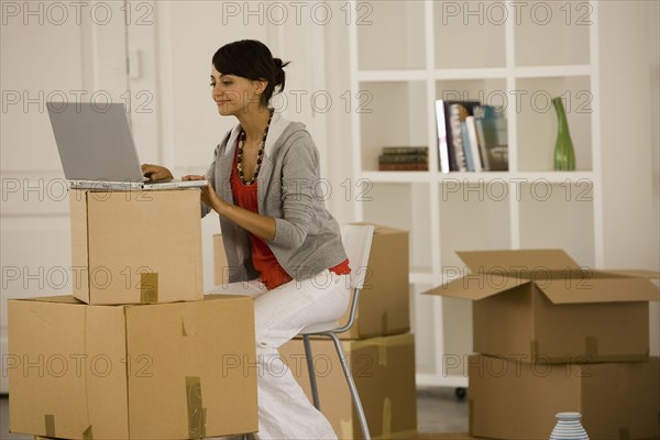 Woman using laptop in new house