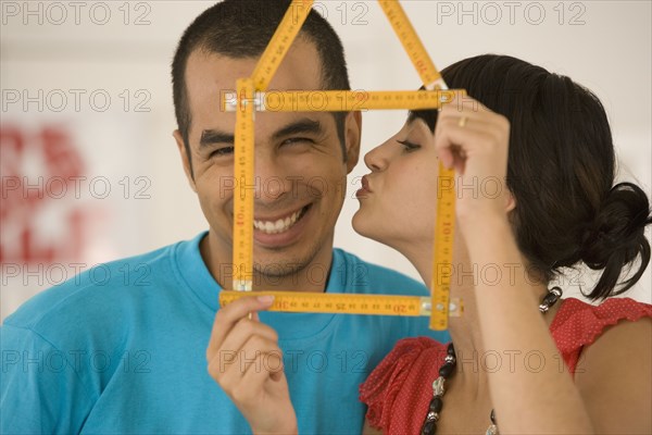 Couple holding folding ruler shaped like house