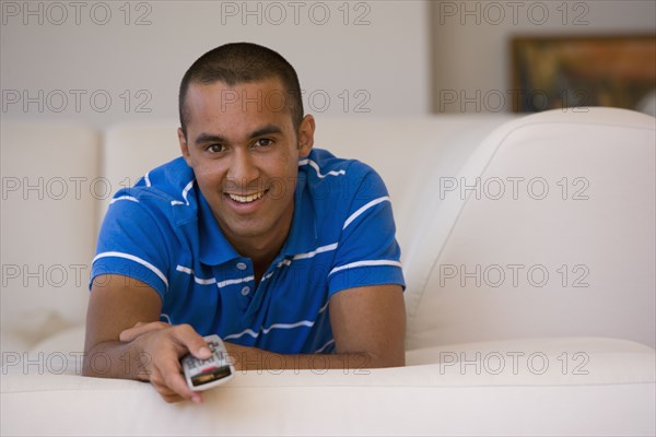 Young man pointing remote control