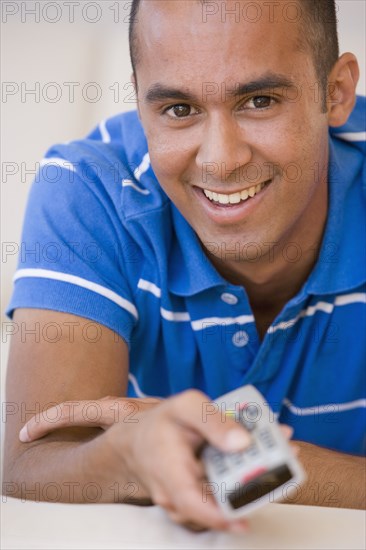 Young man pointing remote control