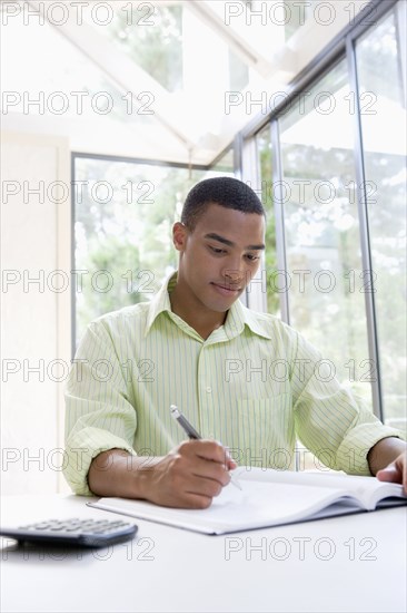 African man writing in notebook