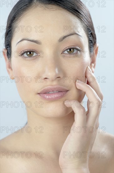Mixed Race woman with hand on face