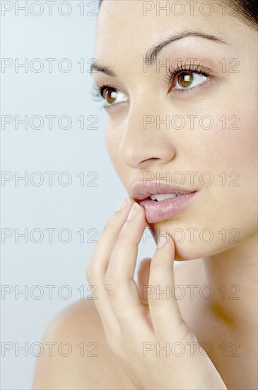 Mixed Race woman with hand on chin