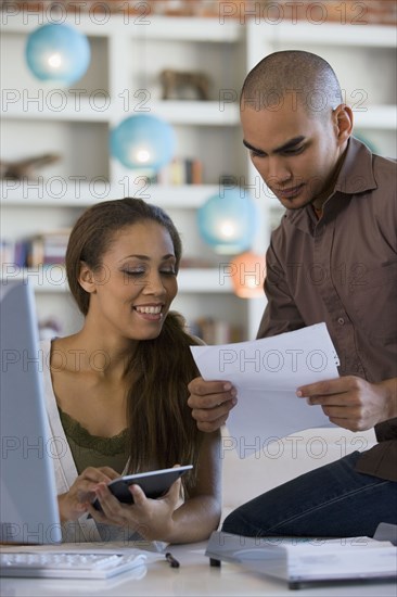 African American couple paying bills online