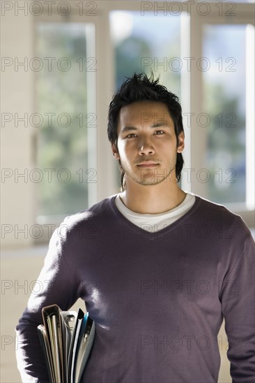 Asian man carrying binders