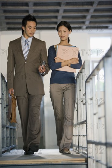 Asian businesspeople walking in hallway