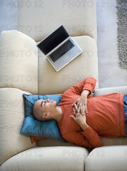 African American man sleeping on sofa