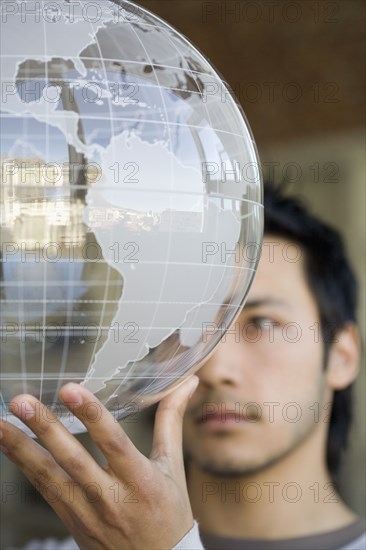 Asian man holding globe