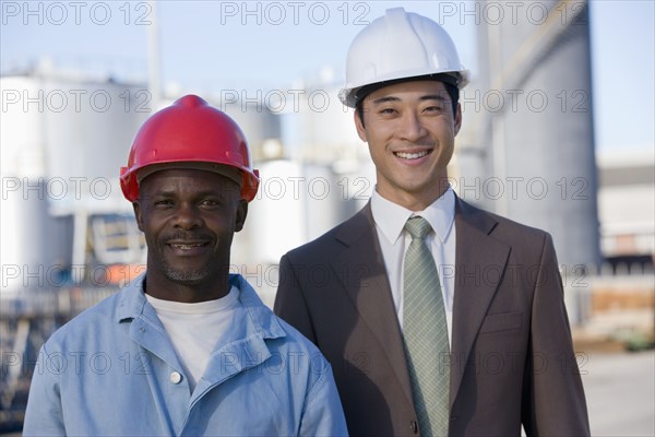 Multi-ethnic businessman and construction worker wearing hardhats