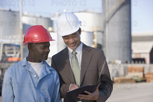 Multi-ethnic businessman and construction worker looking at paperwork