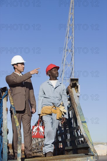 Multi-ethnic businessman and construction worker walking