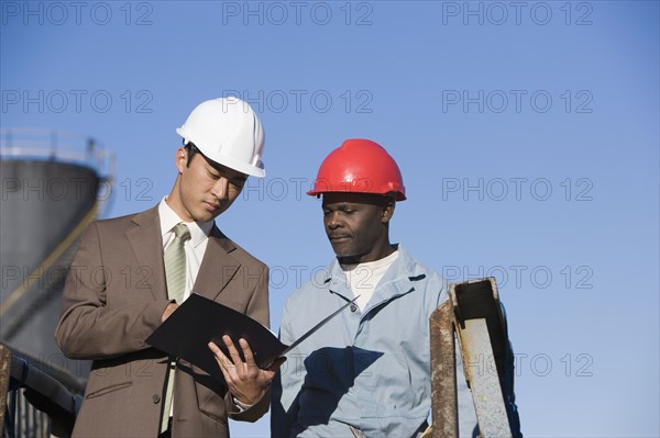 Multi-ethnic businessman and construction worker looking at paperwork