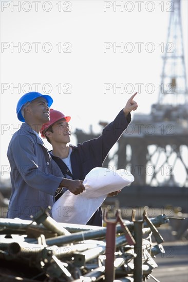 Multi-ethnic male construction workers pointing