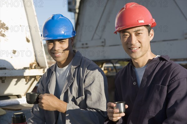 Multi-ethnic male construction workers drinking coffee
