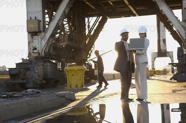 African American businesspeople wearing hardhats