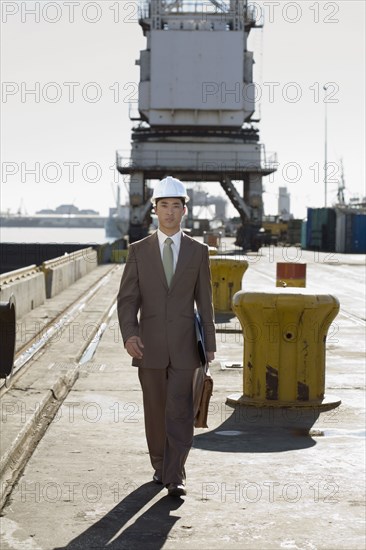 Asian businessman walking on commercial pier