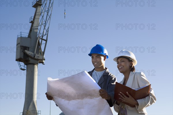 African American businesswoman and construction worker with blueprints