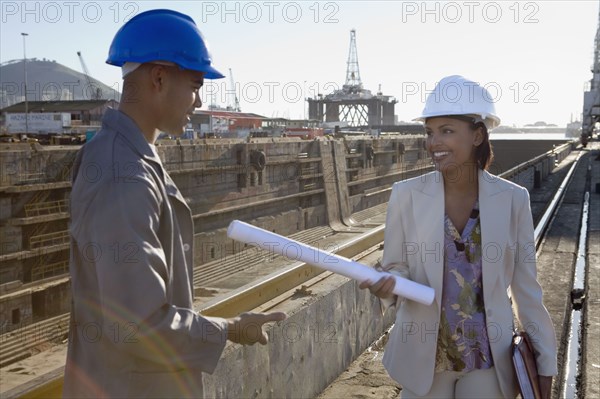 African American businesswoman and construction worker with blueprints