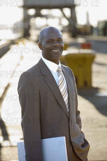 African American businessman holding laptop